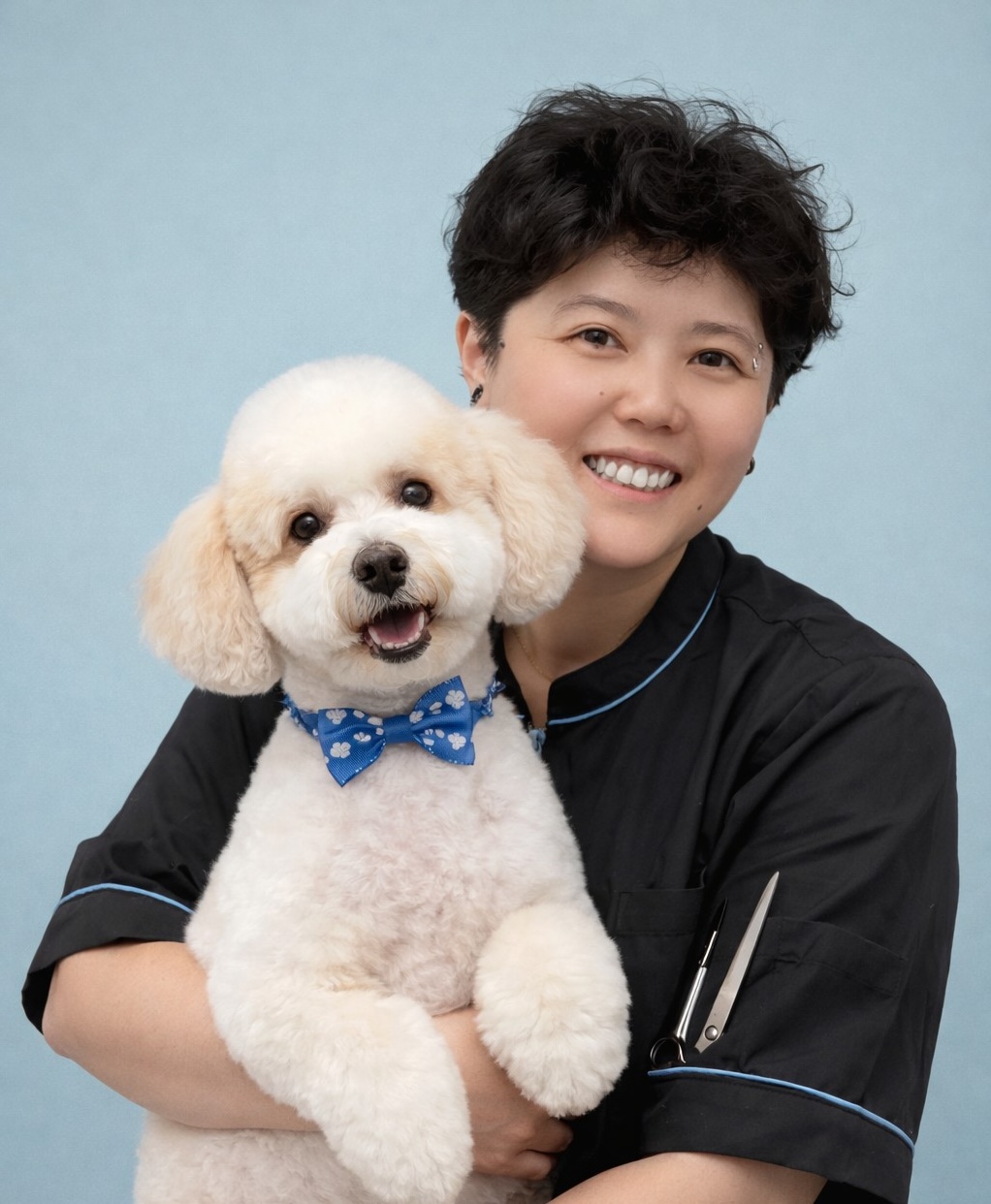 Wylie Shen, founder of Unicorn Pet Grooming Salon, holding a freshly groomed poodle